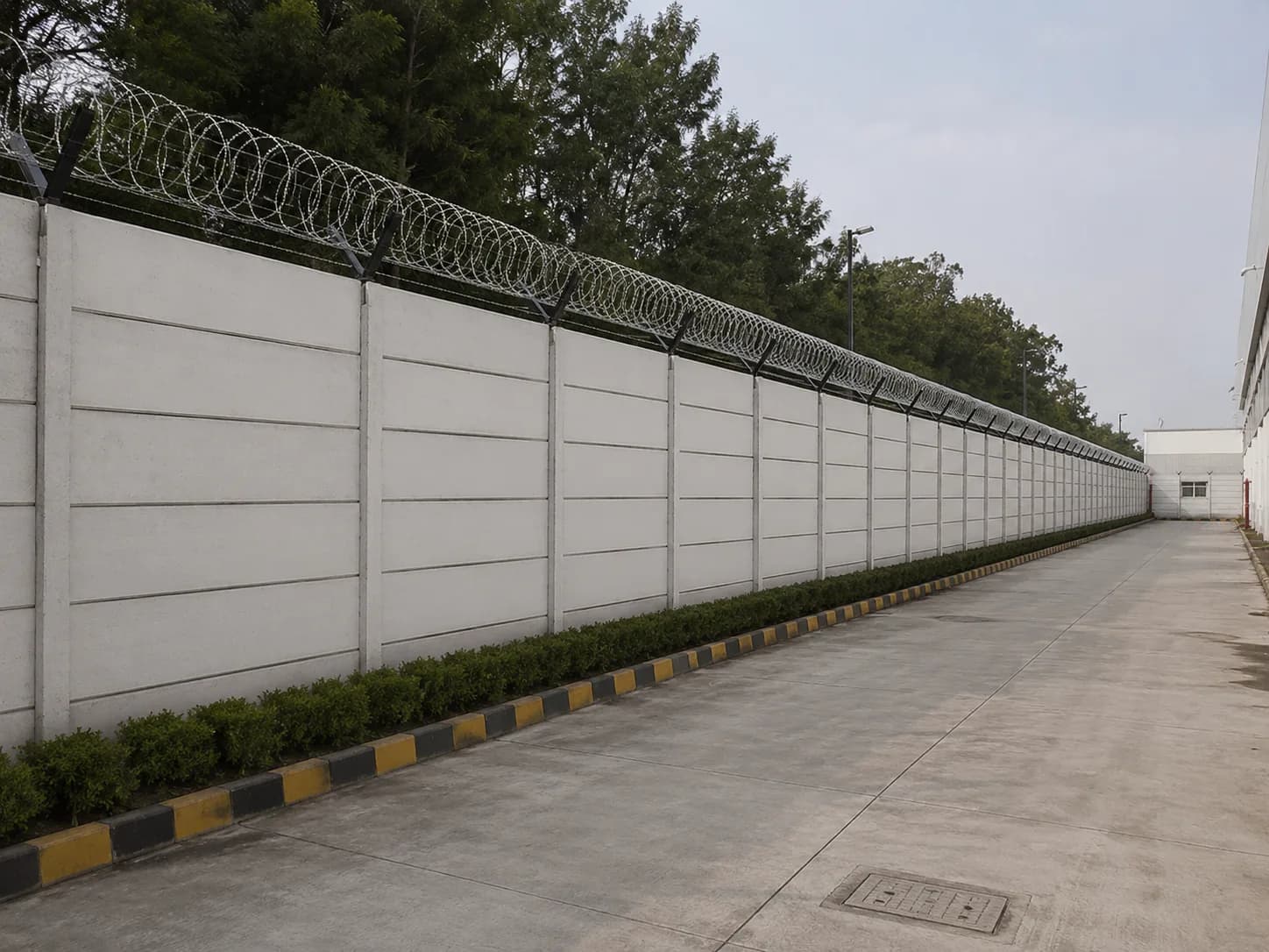 Precast security wall with barbed wire fitted along the top edge